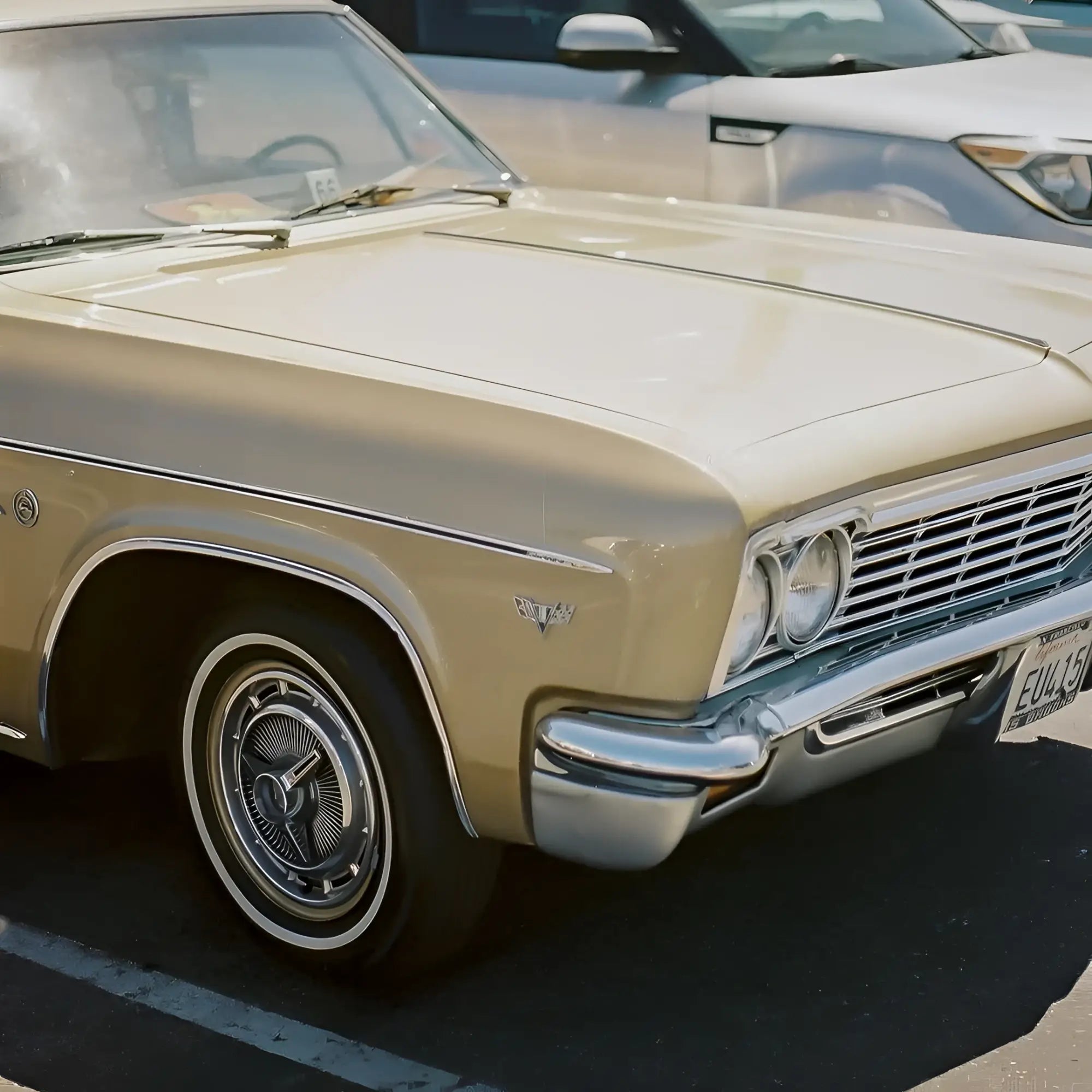 Beige 1960s chevrolet impala with chrome accents and whitewall tires on candido c41 color 400 iso 35mm color negative film