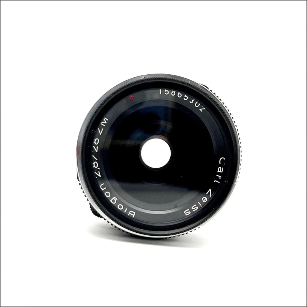 Black carl zeiss biogon 87mm f/2.0 lens with a sleek, metallic finish and engraved markings on the barrel.