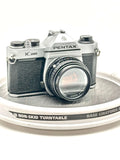 Silver and black asahi pentax k-1000 film camera with a textured leather grip.