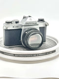 Silver and black asahi pentax k-1000 film camera with a textured leather grip.