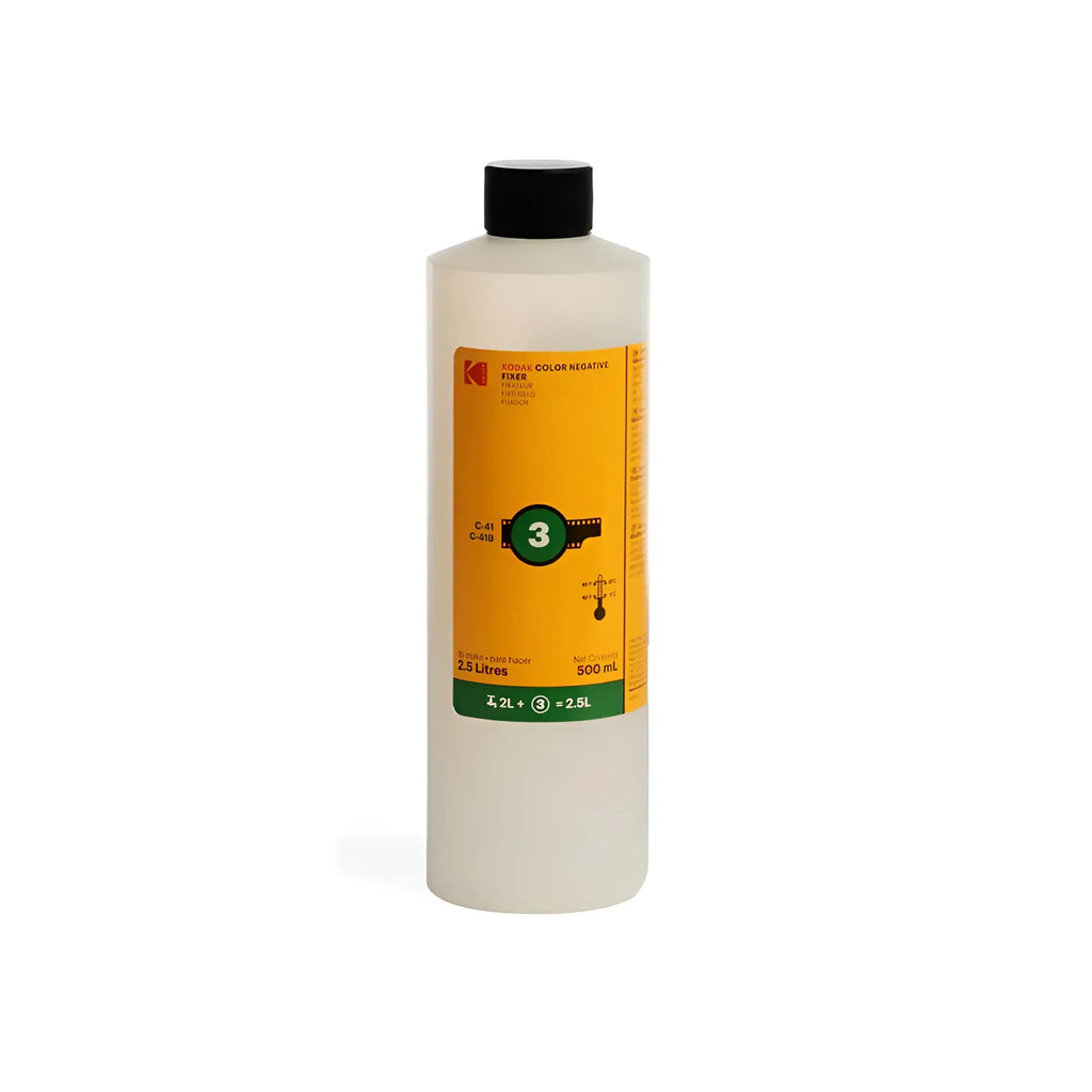 A 500 ml bottle of kodak color negative fixer, featuring a translucent white body and a black cap with an orange label displaying the brand name and product information.