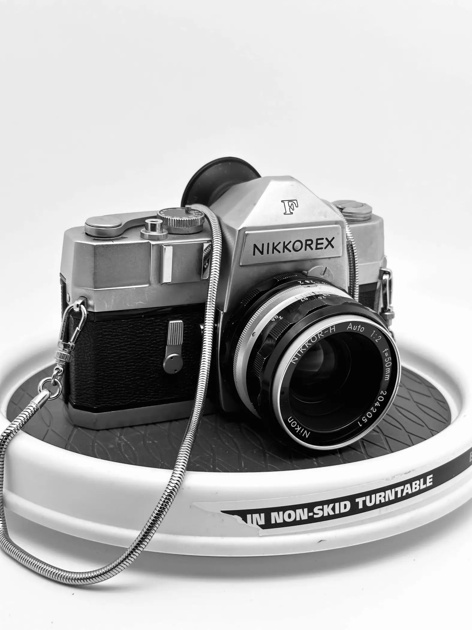 Silver and black nikkorex f camera with a nikkor-h auto 1:2 lens.